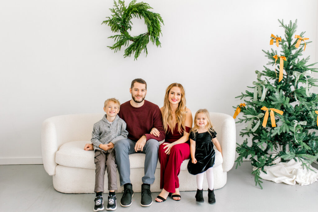 minimalist Christmas backdrop of a white couch and Christmas tree