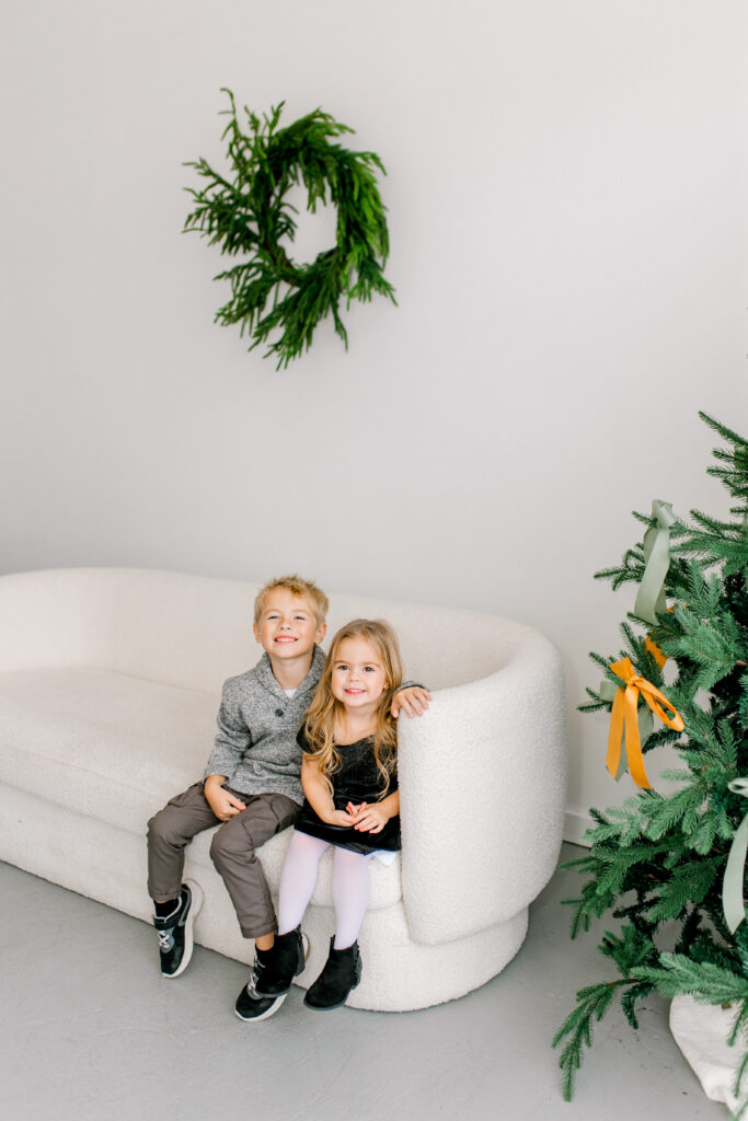 minimalist Christmas backdrop of a white couch and Christmas tree