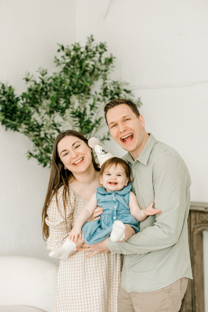 Parents holding their one year old daughter during first birthday photos