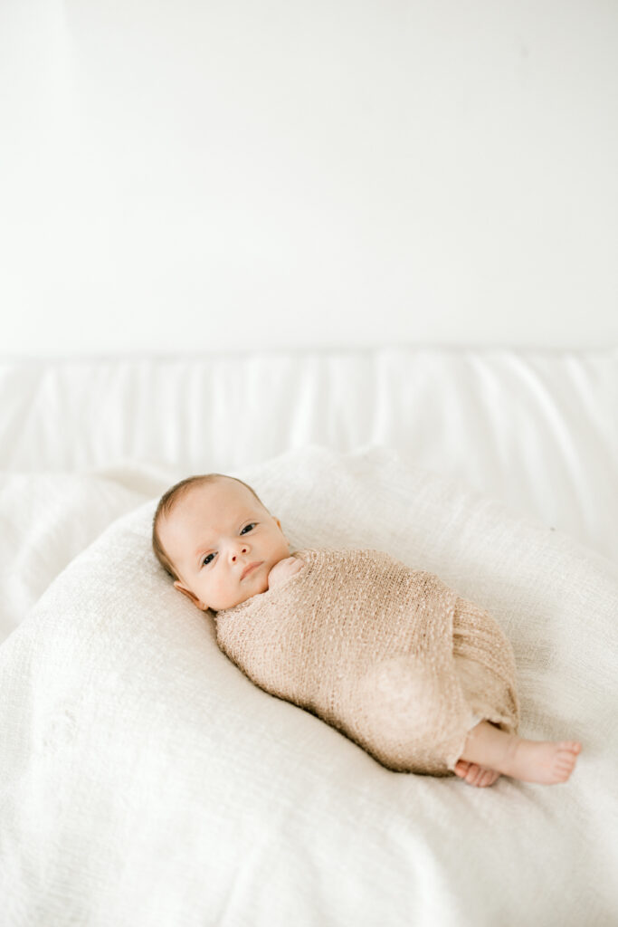 Baby Beau wrapped and sleeping peacefully in studio newborn session